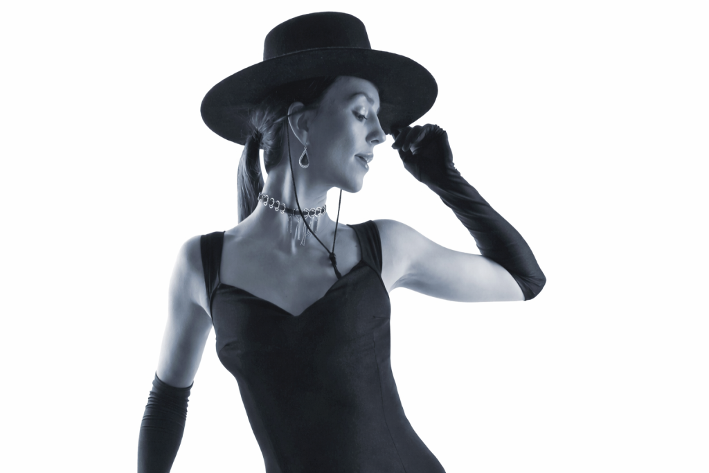 Iconic black and white GUESS girl fashion photography featuring a vintage hat and gloves for a timeless brand aesthetic